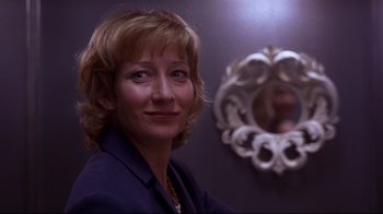Movie still from “Secretary” (2002), directed by Steven Shainberg – A person in a room near a mirror; Close Up shot, Low angle