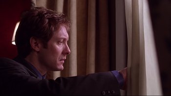 Movie still from “Secretary” (2002), directed by Steven Shainberg – A person looking out a window; Close Up shot, Low angle