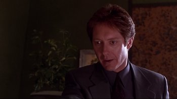 Movie still from “Secretary” (2002), directed by Steven Shainberg – A person wearing a suit and tie; Close Up shot, Over the shoulder angle
