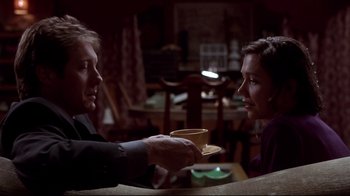 Movie still from “Secretary” (2002), directed by Steven Shainberg – A man and a woman holding a cup of coffee; Medium shot, Over the shoulder angle