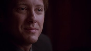 Movie still from “Secretary” (2002), directed by Steven Shainberg – A man's face in a dark room; Close Up shot, Over the shoulder angle