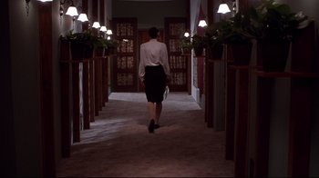 Movie still from “Secretary” (2002), directed by Steven Shainberg – A woman walking down a hall way in a building; Wide shot, Low angle