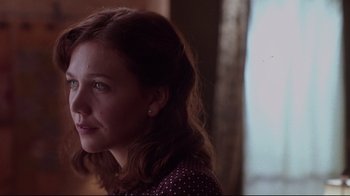 Movie still from “Secretary” (2002), directed by Steven Shainberg – A young woman is looking out a window; Close Up shot, Over the shoulder angle