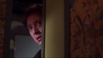Movie still from “Secretary” (2002), directed by Steven Shainberg – A man looking out of a window at the camera; Close Up shot, Low angle