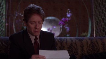 Movie still from “Secretary” (2002), directed by Steven Shainberg – A man wearing a suit and tie looking at a piece of paper; Close Up shot, Over the shoulder angle