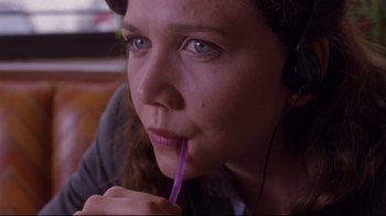 Movie still from “Secretary” (2002), directed by Steven Shainberg – A person holding a straw in her mouth; Close Up shot, High angle