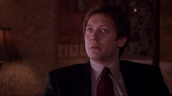 Movie still from “Secretary” (2002), directed by Steven Shainberg – A person wearing a suit and tie; Close Up shot, Low angle