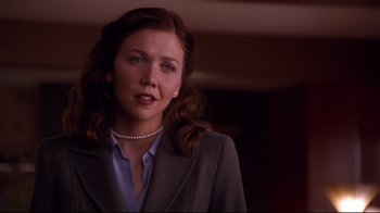 Movie still from “Secretary” (2002), directed by Steven Shainberg – A woman in a business suit with a pearl necklace; Close Up shot, Over the shoulder angle
