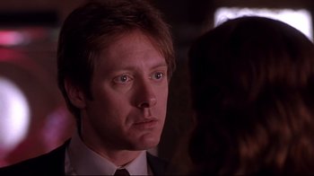 Movie still from “Secretary” (2002), directed by Steven Shainberg – A person wearing a suit and tie; Close Up shot, Over the shoulder angle