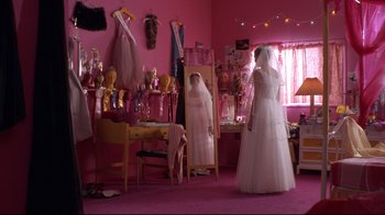 Movie still from “Secretary” (2002), directed by Steven Shainberg – Two women in a pink room , one in a white dress; Wide shot, High angle