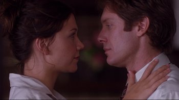 Movie still from “Secretary” (2002), directed by Steven Shainberg – A man and a woman face to face in a room; Close Up shot, Low angle