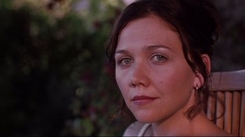 Movie still from “Secretary” (2002), directed by Steven Shainberg – A woman's face in front of a bush; Close Up shot, Low angle