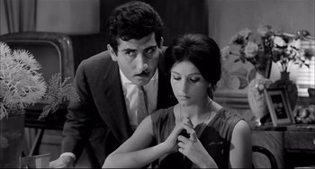 Movie still from “Seduced and Abandoned” (1964), directed by Pietro Germi – A man and a woman looking at each other in black and white; Medium shot, Low angle