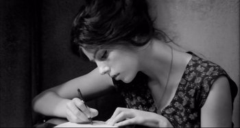 Movie still from “Seduced and Abandoned” (1964), directed by Pietro Germi – A woman writing on a piece of paper with a pen; Close Up shot, High angle