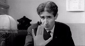 Movie still from “Seduced and Abandoned” (1964), directed by Pietro Germi – A black and white photo of a man in a suit and tie; Close Up shot, Low angle