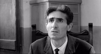 Movie still from “Seduced and Abandoned” (1964), directed by Pietro Germi – Black and white photograph of a man in a suit; Close Up shot, Low angle
