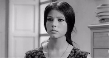 Movie still from “Seduced and Abandoned” (1964), directed by Pietro Germi – A young woman with long black hair wearing a necklace; Close Up shot, Low angle