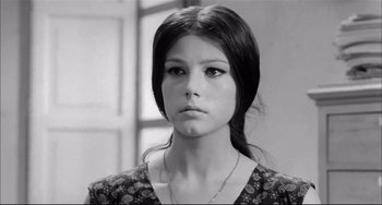 Movie still from “Seduced and Abandoned” (1964), directed by Pietro Germi – A young woman with long black hair wearing a necklace; Close Up shot, Low angle