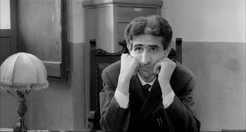 Movie still from “Seduced and Abandoned” (1964), directed by Pietro Germi – A black and white photo of a man in a suit and tie; Close Up shot, Low angle