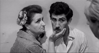 Movie still from “Seduced and Abandoned” (1964), directed by Pietro Germi – An older woman and a younger man looking at each other; Close Up shot, Low angle