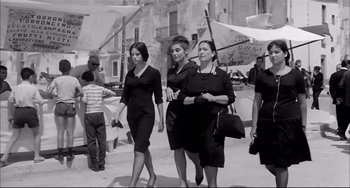 Movie still from “Seduced and Abandoned” (1964), directed by Pietro Germi – A group of women walking down a street; Medium shot, Low angle