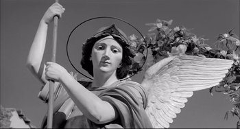 Movie still from “Seduced and Abandoned” (1964), directed by Pietro Germi – A statue of an archangel holding a staff; Medium shot, Low angle