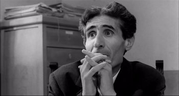 Movie still from “Seduced and Abandoned” (1964), directed by Pietro Germi – Black and white photograph of a man in a suit; Close Up shot, Low angle