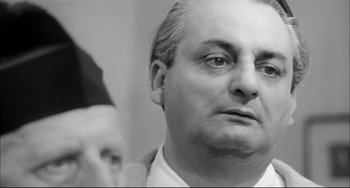 Movie still from “Seduced and Abandoned” (1964), directed by Pietro Germi – Black and white photograph of a man looking at himself in the mirror; Close Up shot, Low angle