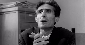 Movie still from “Seduced and Abandoned” (1964), directed by Pietro Germi – Black and white photograph of a man in a suit; Close Up shot, Low angle