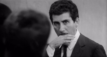 Movie still from “Seduced and Abandoned” (1964), directed by Pietro Germi – A black and white photo of a man in a suit and tie; Close Up shot, Low angle