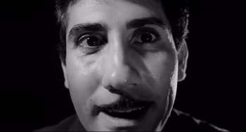 Movie still from “Seduced and Abandoned” (1964), directed by Pietro Germi – A black and white photo of a man with a mustache; Extreme Close Up shot, Low angle