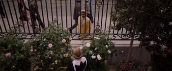 Movie still from “See You Up There” (2017), directed by Albert Dupontel – A man in a yellow jacket standing in front of a fence; Wide shot, High angle