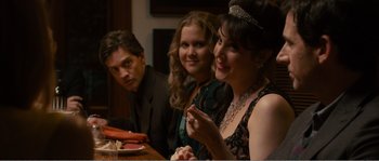 Movie still from “Seeking a Friend for the End of the World” (2012), directed by Lorene Scafaria – A group of people sitting around a table; Medium shot, Over the shoulder angle