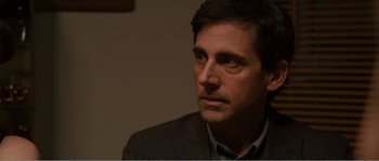 Movie still from “Seeking a Friend for the End of the World” (2012), directed by Lorene Scafaria – A person wearing a suit and tie; Close Up shot, Over the shoulder angle