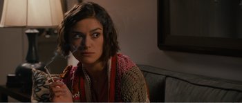 Movie still from “Seeking a Friend for the End of the World” (2012), directed by Lorene Scafaria – A woman sitting on a couch with a cigarette in her mouth; Close Up shot, Over the shoulder angle