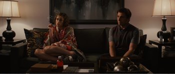 Movie still from “Seeking a Friend for the End of the World” (2012), directed by Lorene Scafaria – A man and a woman sitting on a black couch; Wide shot, Over the shoulder angle