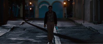 Movie still from “Seeking a Friend for the End of the World” (2012), directed by Lorene Scafaria – A man walking down a street at night; Wide shot, Over the shoulder angle