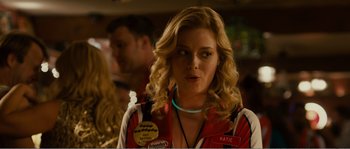 Movie still from “Seeking a Friend for the End of the World” (2012), directed by Lorene Scafaria – A woman with blonde curly hair wearing a red and white shirt; Close Up shot, Over the shoulder angle