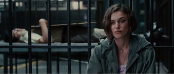 Movie still from “Seeking a Friend for the End of the World” (2012), directed by Lorene Scafaria – A woman sitting in front of a metal fence; Close Up shot, Over the shoulder angle