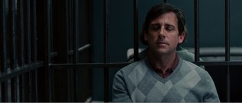 Movie still from “Seeking a Friend for the End of the World” (2012), directed by Lorene Scafaria – A man sitting in front of a cage in a jail cell; Close Up shot, Over the shoulder angle