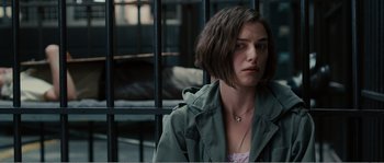 Movie still from “Seeking a Friend for the End of the World” (2012), directed by Lorene Scafaria – A woman in a green jacket standing in front of a metal fence; Close Up shot, Over the shoulder angle