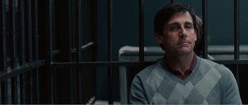 Movie still from “Seeking a Friend for the End of the World” (2012), directed by Lorene Scafaria – A man sitting behind bars in a jail cell; Close Up shot, Over the shoulder angle