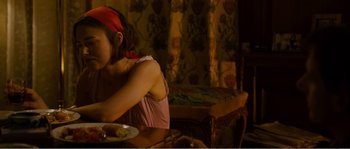 Movie still from “Seeking a Friend for the End of the World” (2012), directed by Lorene Scafaria – A woman sitting at a table with a plate in front of her; Medium shot, Over the shoulder angle