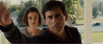 Movie still from “Seeking a Friend for the End of the World” (2012), directed by Lorene Scafaria – A man and a woman standing next to each other in front of trees; Close Up shot, Over the shoulder angle