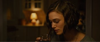 Movie still from “Seeking a Friend for the End of the World” (2012), directed by Lorene Scafaria – A woman is holding a glass of wine in her hand; Close Up shot, Over the shoulder angle