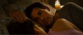 Movie still from “Seeking a Friend for the End of the World” (2012), directed by Lorene Scafaria – A person laying in a bed near a candle; Close Up shot, High angle
