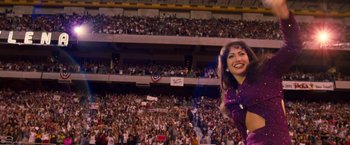 Movie still from “Selena” (1997), directed by Gregory Nava – A woman in a purple dress is in a crowd of people; Extreme Wide shot, Low angle