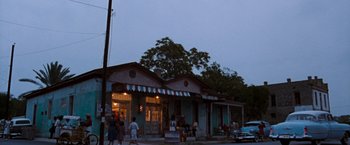 Movie still from “Selena” (1997), directed by Gregory Nava – A group of people standing in front of a building; Extreme Wide shot, Low angle