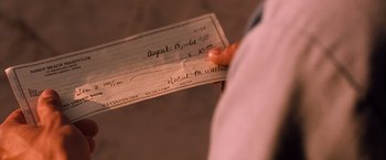 Movie still from “Selena” (1997), directed by Gregory Nava – A person holding a cheque in their hand; Extreme Close Up shot, Over the shoulder angle