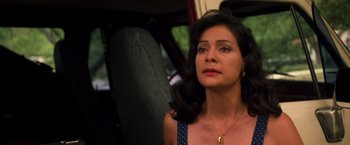 Movie still from “Selena” (1997), directed by Gregory Nava – A woman sitting in a car looking off into the distance; Close Up shot, High angle